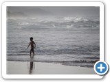 A young boy enjoys evening surf at Cattlewash